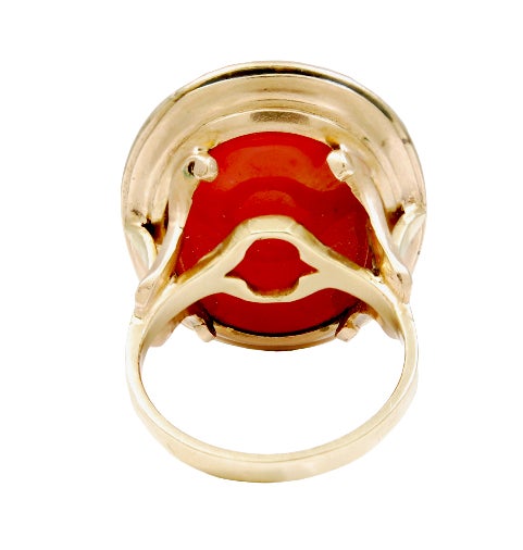 A GEORGIAN GOLD AND CARNELIAN SIGNET RING, ENGRAVED WITH A CREST FEATURING A WELSH DRAGON ATOP AN ENGRAVED SHIELD, THE MOUNT WITH TREFOIL SHOULDERS TO A SLIM SHANK
