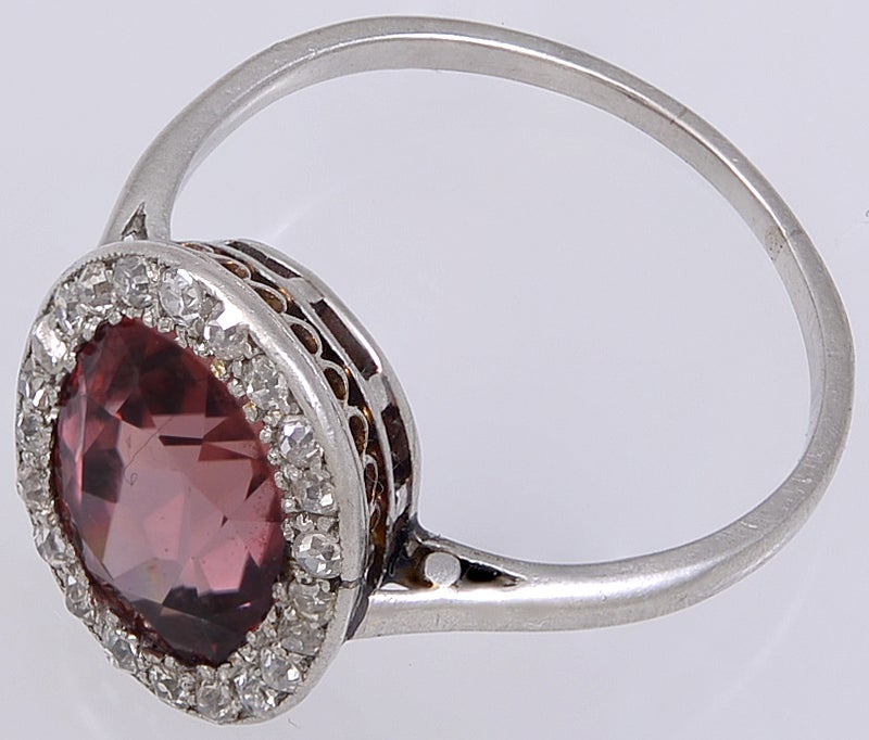 A pretty Edwardian Ring,set with a Pinky/Brown Zircon which would have been found in the gem mines of old Ceylon, with a surround of twenty two small European cut Diamonds in a Platinum Mount. 
This Ring would make an ideal Engagement Ring for the