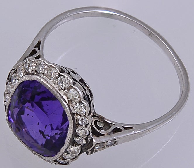 ANOTHER BEAUTIFUL RING FROM THE EDWARDIAN ERA, SET WITH A RARE NATURAL COLOUR PURPLE SAPPHIRE(G.I.A.)AND A SURROUND OF TWENTY TWO SMALL DIAMONDS WITH A FURTHER TWO ON EACH SHOULDER.THE REVERSE OF THE BEZEL HAS AN INTRICATE HAND MADE PLATINUM GALLERY