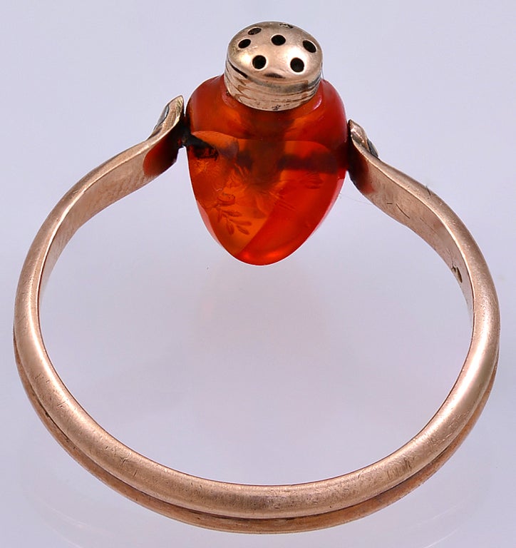 A revolving Carnelian double sided Intaglio in the form of a Pomander (a container of sweet smelling scent) with a pierced Gold top and an Intaglio of a flower filled Cornucopia,the reverse with a Dove bearing an olive branch.
There is a small chip