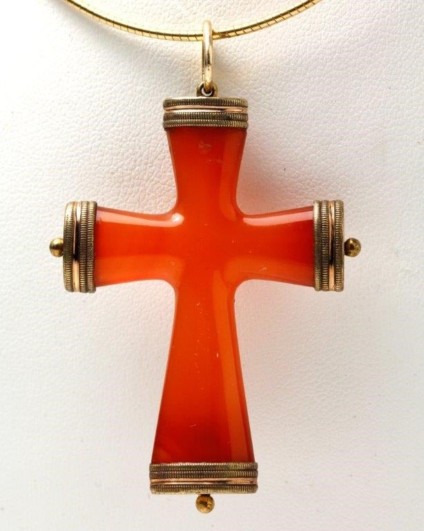 This small Cross is carved from a single piece of richly coloured Carnelian which is pleasantly rounded and capped in Gold at the four points. A Cross of simple beauty.