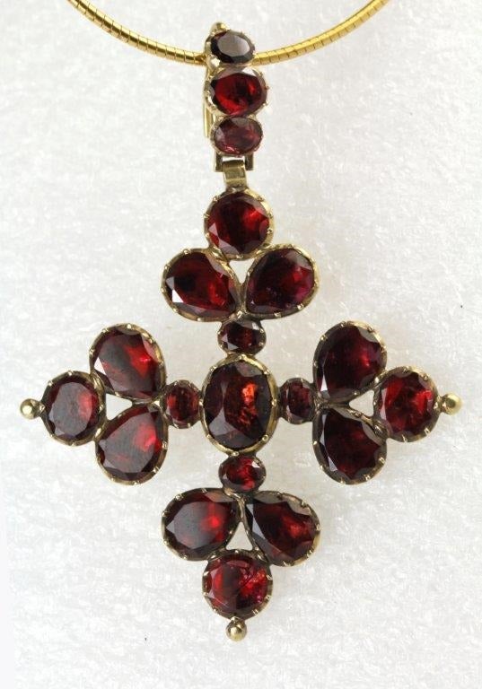 A flat cut Garnet Cross in a closed back Gold mount. This type of garnet, flat with faceted edges, was very popular in Georgian England and I have seen pieces inscribed as early as 1730 and the fashion continued until at least 1820. This Cross is a