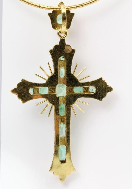 An antique Spanish Emerald and Gold Cross in good condition and set with eleven Emeralds of pleasant even colour and with the original Emerald set suspension bale.