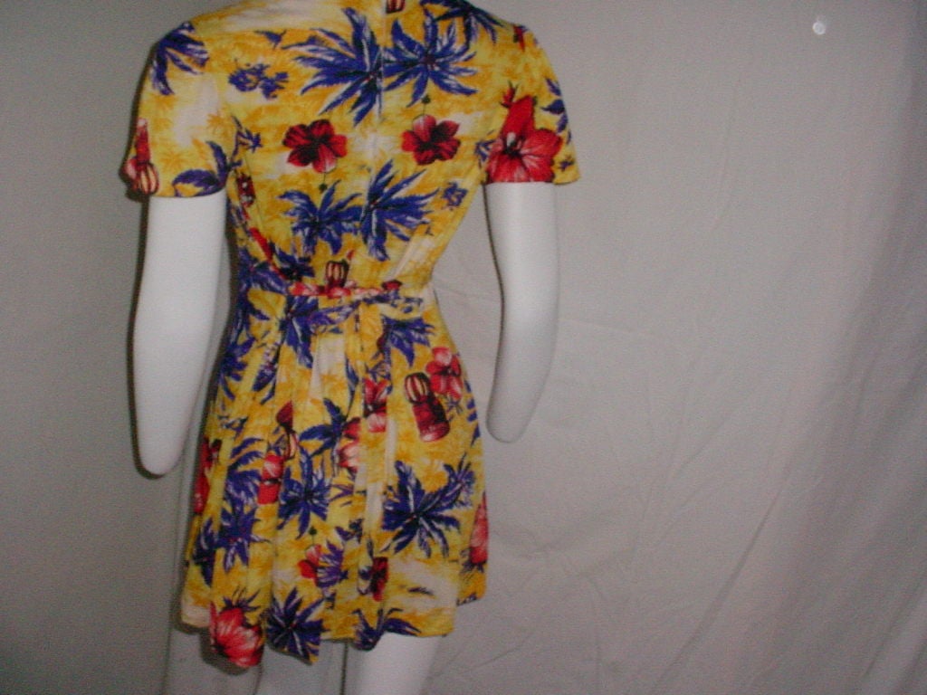 Vintage 70's does 40's mini dress. Hawaiian style tropical print. Center back zipper. Ties in back. Excellent condition, some slight fading in the print, blends in and is difficult to see.