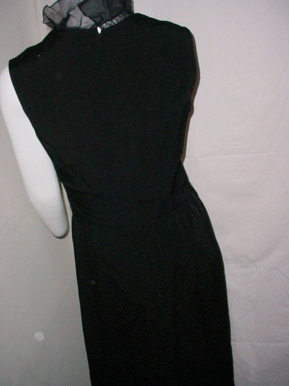Vintage long black dress by Nat Kaplan New York. Black rayon or silk with organza ruffle. Excellent condition. Long 1960s sheath with ruffle trim and slit.

36 inch bust
26 inch waist
40 inch hips
57 inches long