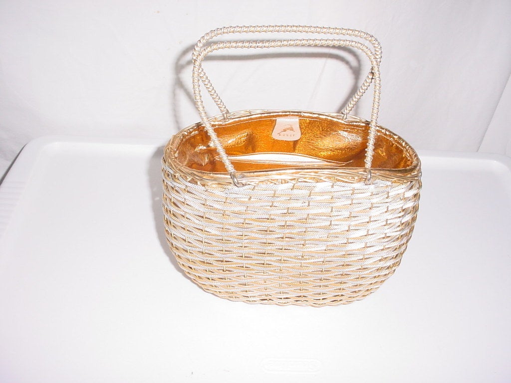 Vintage 1950s gold and silver metal basket bag by Koret. With beautiful gold lining and change purse. Metal handles. Excellent condition, appears to be unused.