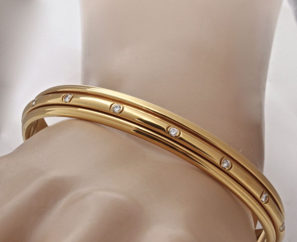 This beautiful bangle bracelet from Piaget is a classic. The center row of gold and diamonds spins around the larger band. What a great detail. This recognizable design is a must-have of any great jewelry collection. This is a BRAND NEW Bangle