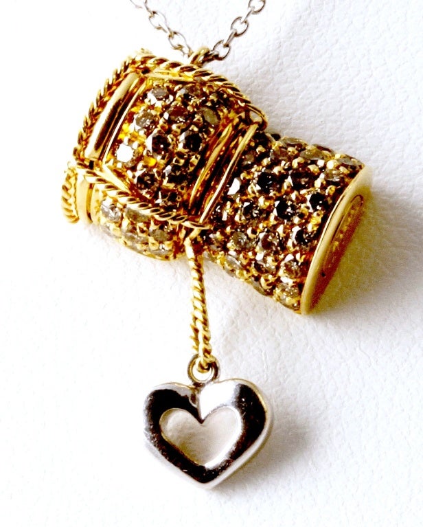 A small 18K white gold heart hangs from the diamond encrusted champagne cork. What's more romantic and fun than champagne? This is a really nice piece from our good friend Roberto Coin. It is BRAND NEW with tags and retails for $1,640