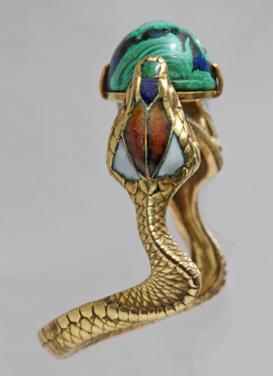 The Hooded Cobras are clutching a blue green cabochon 'World'. 
The crystal is a natural amalgam of malachite and lapis lazuli, long considered to have Metaphysical and Healing Properties.
The snake is considered divine, a symbol of immortality, a