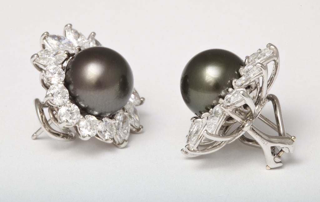 A gorgeous pair of Tiffany & Co., South Sea Cultured Pearl & Diamond earclips.
Each is centering a dark gray South Sea cultured pearl which measures approximately 11.50 to 12.00mm. The pearls are surrounded by pear-shaped, marquise and round