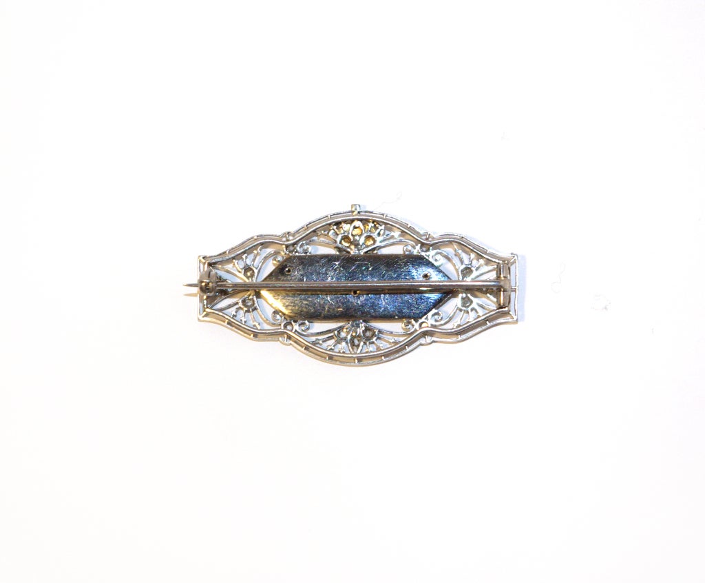 An open work platinum and rose cut diamond brooch with a central blue enamel plaque. Having the rose diamond initials GMR  beneath the royal crown in platinum and red enamel.  Representing  King George V (1910...1936) and Queen Mary (i.e. George