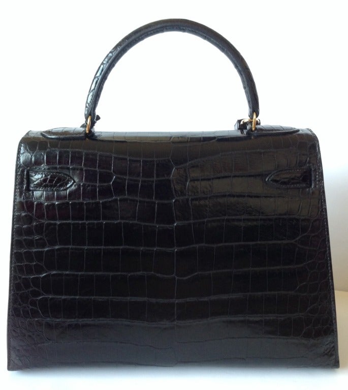 Hermes Kelly 32 Black Porosus crocodile  
 
This bag has been restored at Hermès SPA (receipt will be joined) 
Black shiny crocodile Porosus with gold hardware  
The bag is lined with chevre leather.  
This bag is in excellent condition.
No