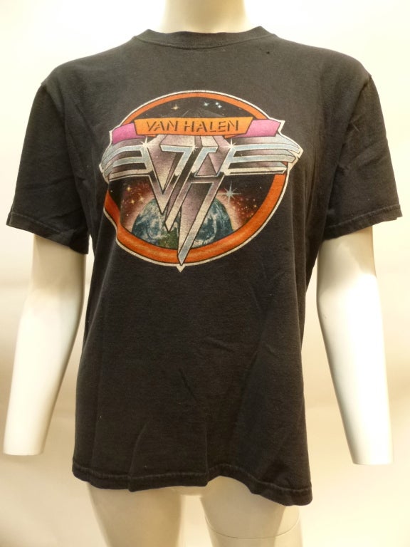 1978 Van Halen promotional t-shirt for their first LP, Van Halen I. The glyph is a little different than that of the LP cover - the banner with the band name is above the metal VH symbol, instead of laid over it.


The tag is mostly gone. Bust: