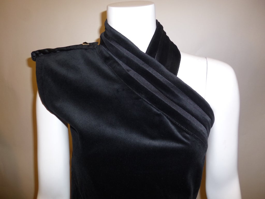 This is an elegant early 1980s Gianni Versace black cotton velvet sleeveless column dress with beautiful bejeweled buttons up the back. The design is very interesting, and makes it quite dramatic while on the body. Lined in silk.

Stated size