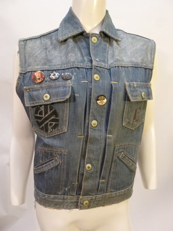 This is a 1960s Ranchcraft denim jacket with the sleeves removed and has a bleached effect with hand-applied paint on the back - Blazin' across the shoulders, a rat and a sort-of anarchy symbol and 'GHOSTGANG' across the bottom hem. A few buttons