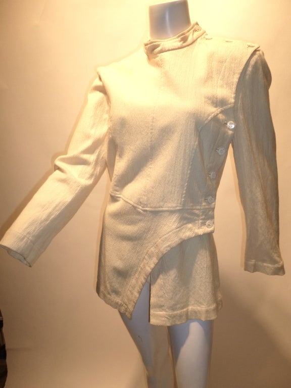 A beautiful and rare 1980s Comme Des Garcons buttoned top in creme. The garment buttons up fully along the side and across the shoulder. Crew neck, asymmetrical front hem.

All measurements are made with the garment lying flat on a table.  Thanks