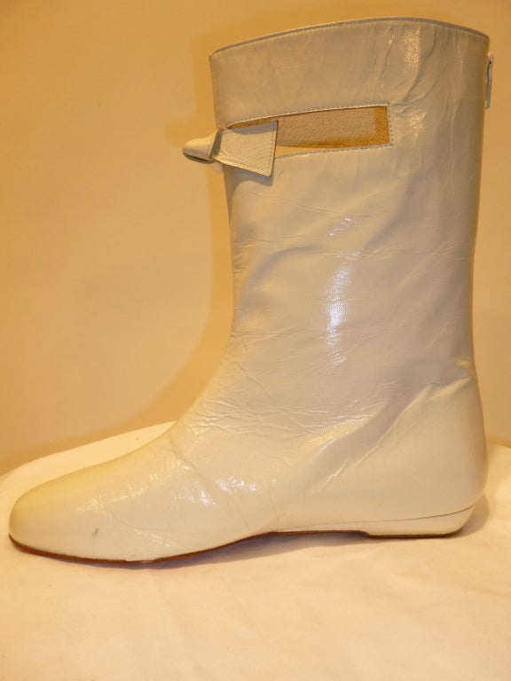 These are iconic Courrèges white patent leather flat boots with a small cut-out at the shin. In image 4 you can see how the leather has settled over the years. The leather is not cracked, it is still quite supple. They have been stored in the box. A
