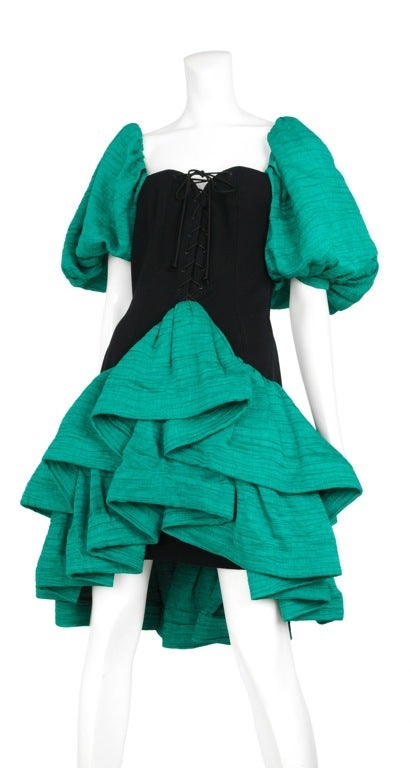 Black corset front cocktail dress with 3 tiered ruffle skirt and large balloon sleeves.