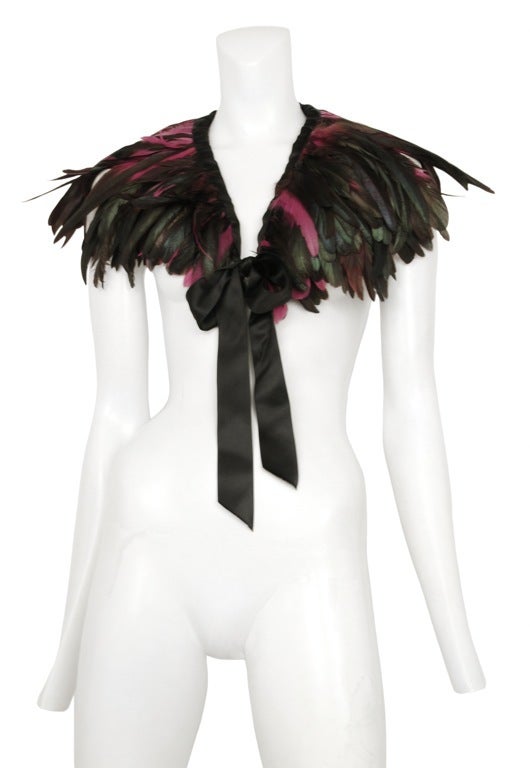 Black, iridescent green caplet with satin trim and tie.