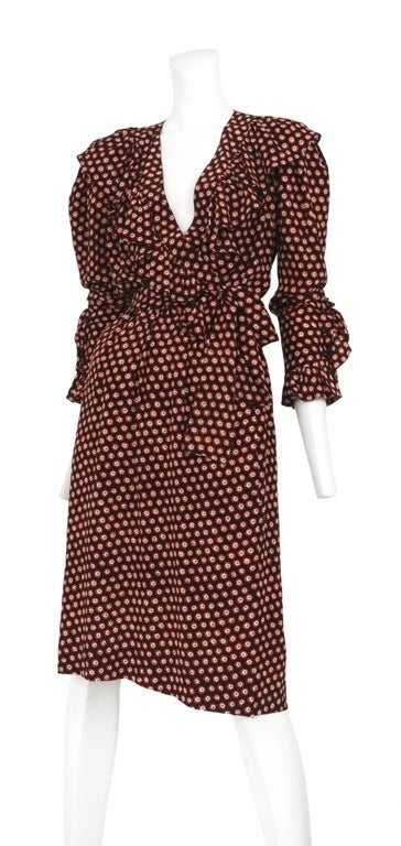 Silk wrap dress with red and black dot print through out. Long sleeves with ruffle cuff and button closure. Classic YSL ruffles accent the neckline and length is just at the knee.