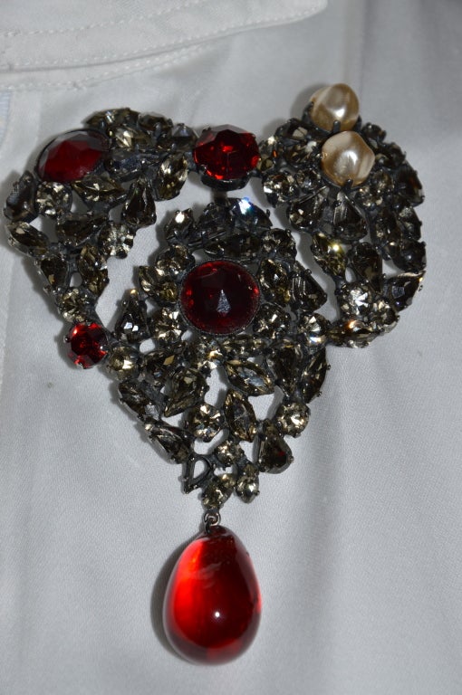 Massive YVES SAINT LAURENT Rive gauche Heart Brooch-Pendant in shades of ruby, black diamonds glass and with faux wild pearls. Design on antique dark silver finish. There is a loop in back for a chain as well.
Jewel first created in 1961, then