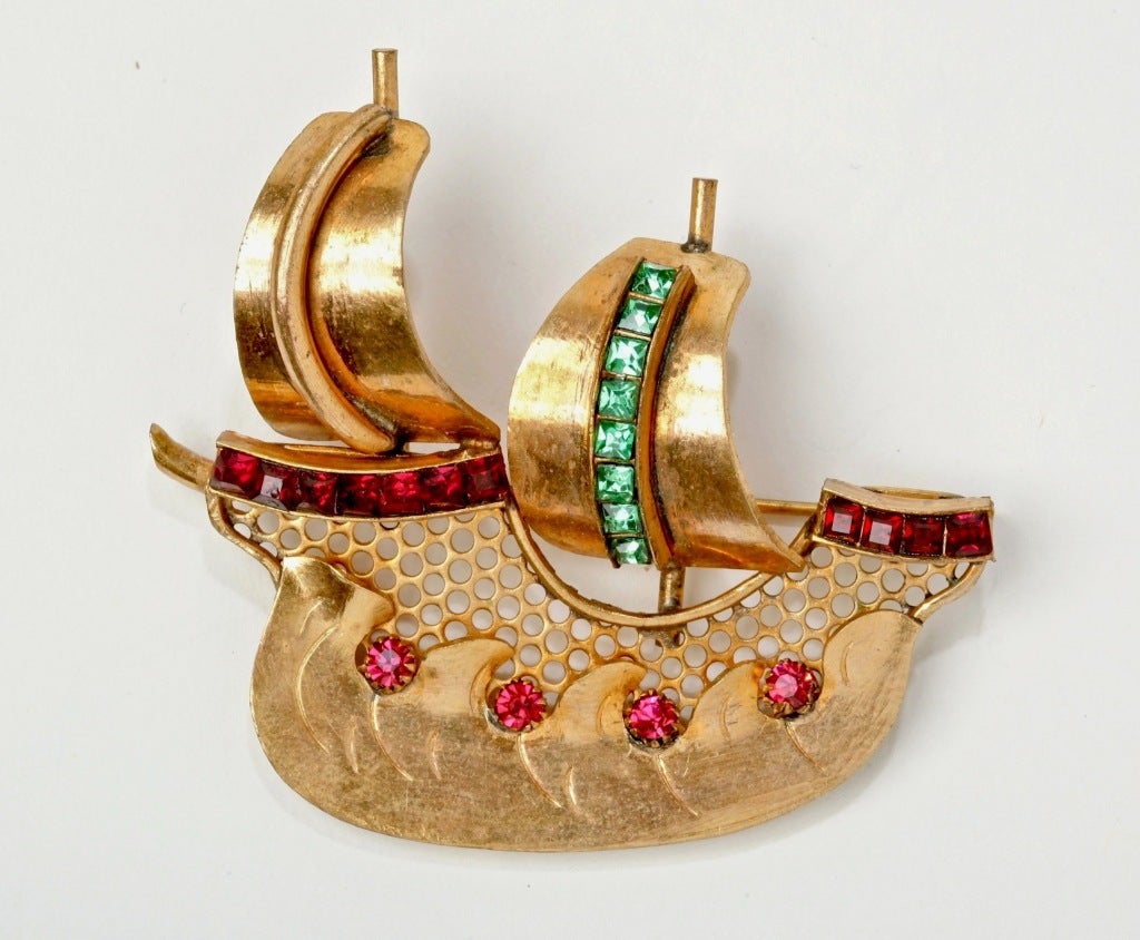 This divine Gilt Metal Brooch set with French Cut Emerald and Ruby pastes and prong set stones is a wonderful whimsical depiction of a Ship in Full Sail.   An unusual and stunning piece.  Signed, Made in France.