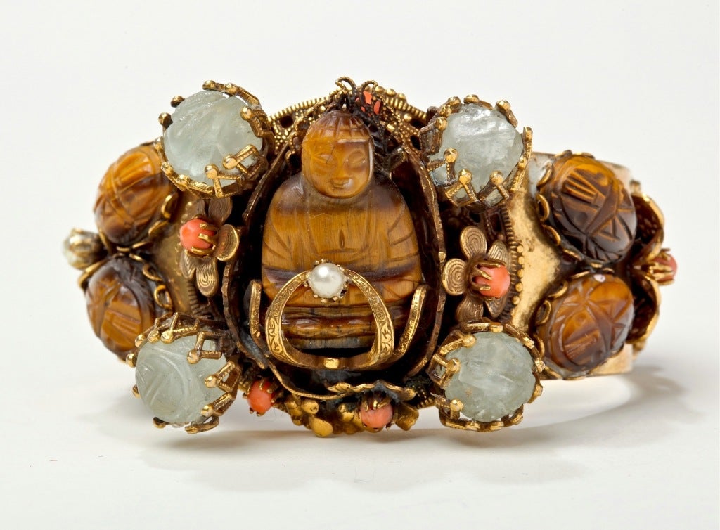 Rare and eye catching bracelet of a large Faux Tiger Eye Buddha holding a pearl surrounded by 4 faux tiger eye scarabs, coral flowers and art glass stones set in prongs...a stunning, unsigned Selro bracelet with undulating griffins, lush colors and
