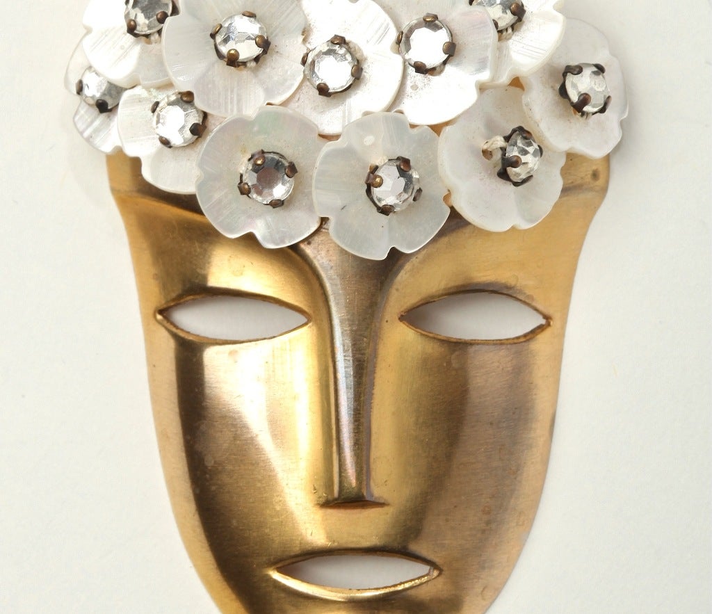 A Fabulous Figural  Fur Clip with Crystal encrusted Mother of Pearl  buttons surmounting a Hagenauer-like mask.