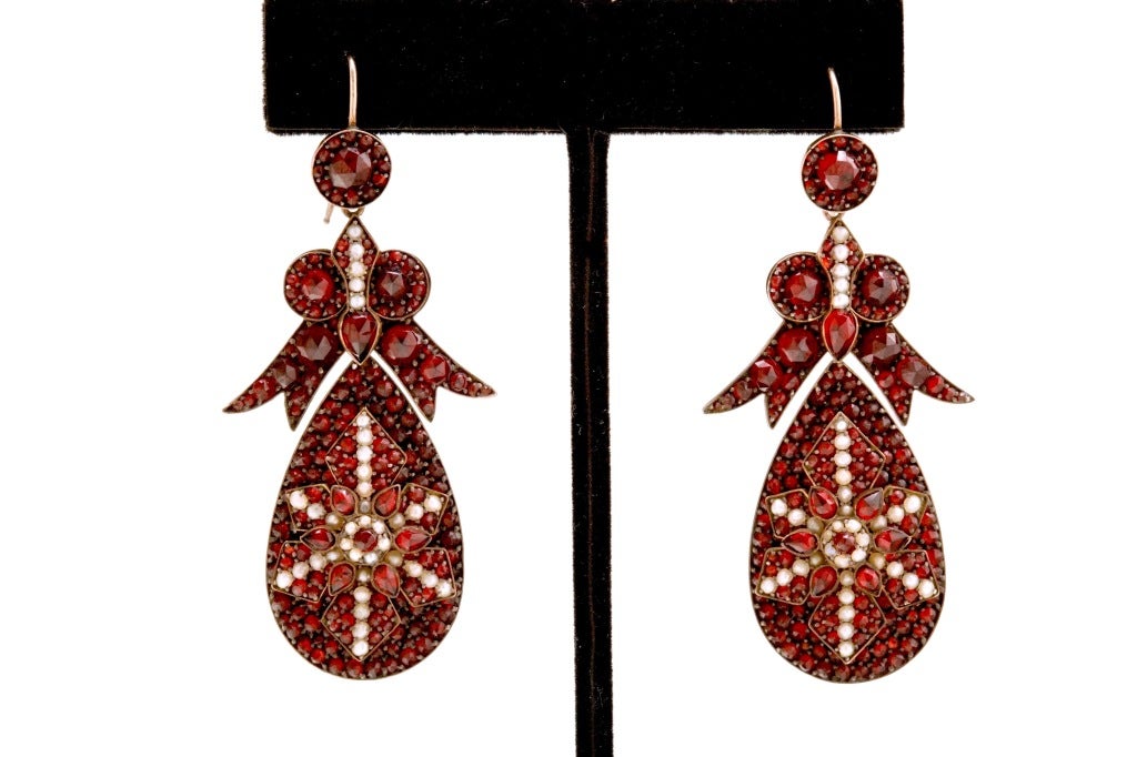 A spectacular pair of antique Bohemian Garnet and Seed Pearl encrusted earrings with large pendant drops surrmounted by beautiful bow form tops and gold wire backs, a truly grand and dramatic pair of earrings, unsigned. The length of the earring not