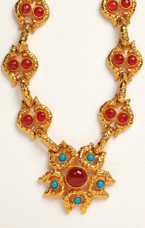 A stunning large scale Cadoro runway necklace with an ornate textured gilt metal chain set with red art glass cabochons ending in a matching pendant accentuated by  tourquoise glass cabochons.
