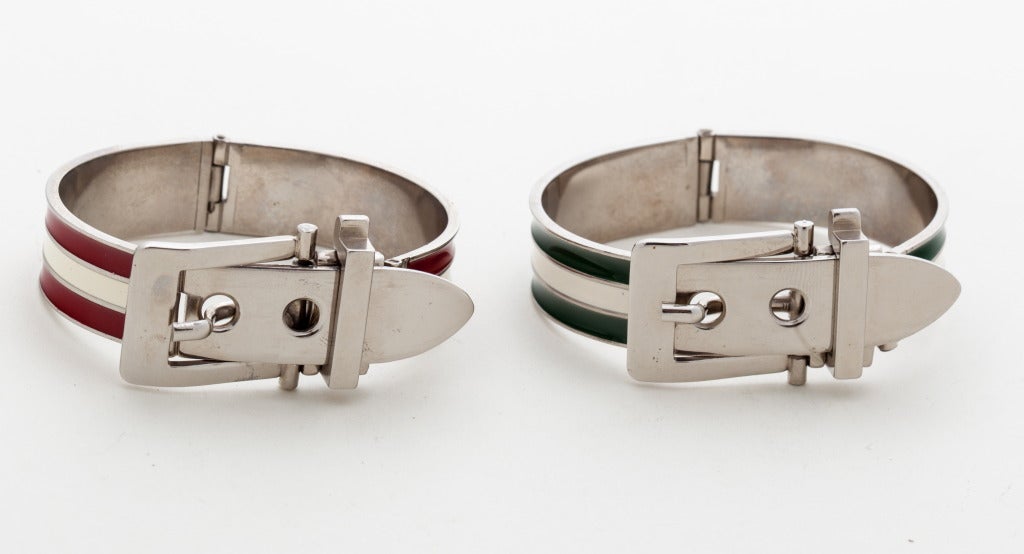 A striking pair of vintage enamel bangles with fully articualted and adjustable buckle clasps in red and white and green and white striped enamel in excellent vintage condition, unsigned.

Note: both bangles adjust to fit a variety of wrist sizes.