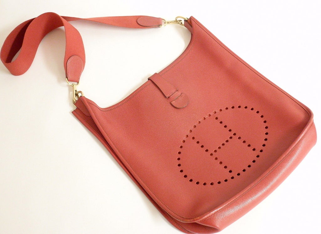 Evelyne GM Courchevel Leather Red Shoulder Bag by Hermes. This bag is in close to like-new condition, very little flaws.

Measurements: 13 inches x 12.5 inches x 3.2 inches

Strap: 30'' total length, When folded, the drop from top of fold to top