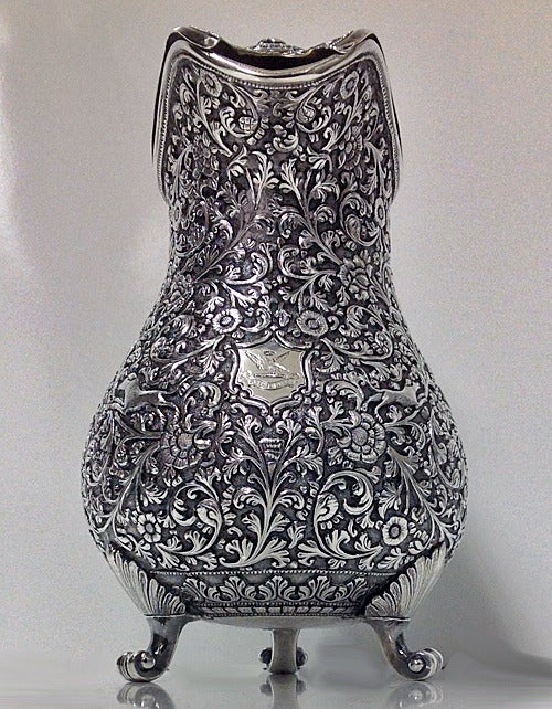 Kutch, India 19th century covered silver jug, circa 1880. The jug of baluster form on three turned scroll feet, the body all hand chased and repousse scrollwork typical of the Kutch regional style, decorated with animals and hunting themes amidst