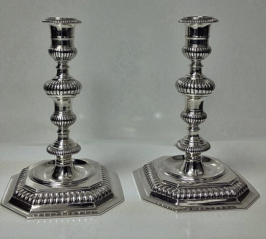 Pair of 17th century style cast candlesticks, London 1963, Carrington & Company. Each on octagonal raised fluted bases, fluted knopped stems and candle socket. Height: 6 ½ inches. Weight: 813.54 grams.