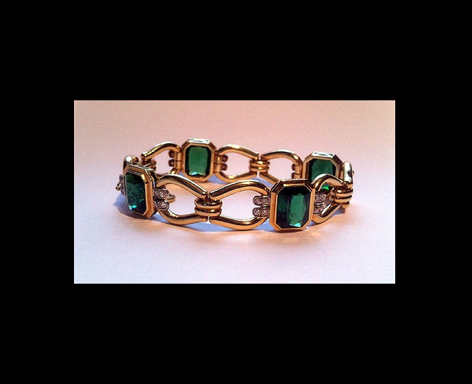 American Tourmaline and 14K Bracelet, 20th century. The Bracelet comprising four bezel set large chamfered fine green tourmaline, each accented with four small single cut diamonds on each side, interspaced with hinged stirrup like links, tongue and