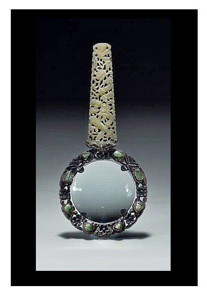 Rare Chinese Export Silver and Jade Magnifying Glass, C.1900. The pierced foliate silver frame bezel set with eight green jadeites, the handle on one side with engraved silver foliate decoration, the other side carved jade plaque handle of tapered