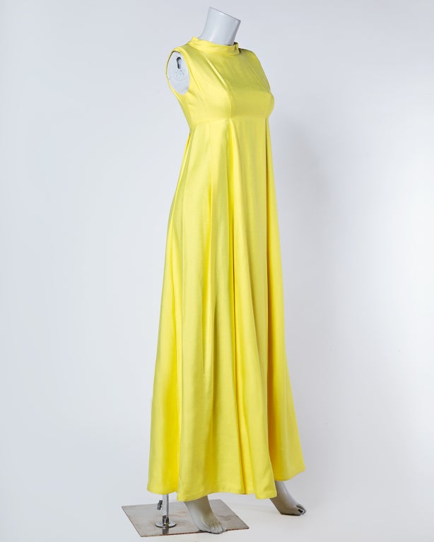 Bright lemon yellow vintage Emma Domb gown from the 1960's. Adorned with a simple singular back bow, this dress is all about the empire silhouette. Sleeveless sleeves. Fully lined. Rear zip closure. 

MEASUREMENTS:

Bust: 35