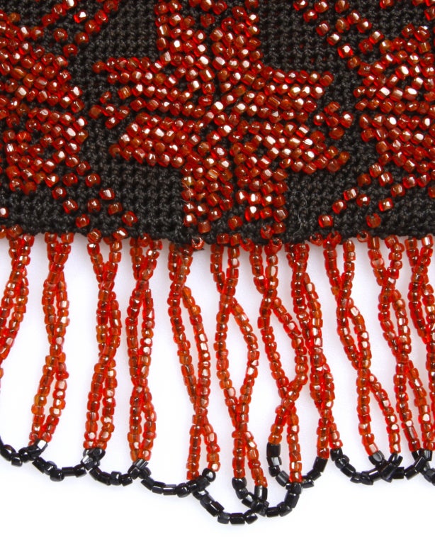 From the Suzanne Mounts Collection:

Possibly the longest 1920s beaded purse we have ever seen. From the top of the handle to the bottom of the loops, the bag is 21 inches long! The bag is 7