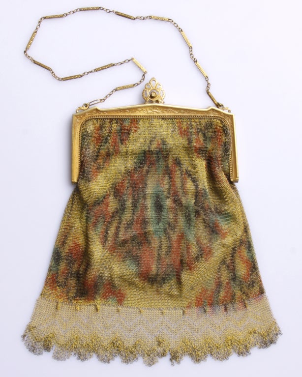 Vintage 1920's Whiting & Davis purse comprised of a gold purse frame and Dresden mesh. The bag is lined in silk and comes with a small metal backed mirror that we found in the interior pocket! Beautifully painted to achieve a watercolor effect. Done