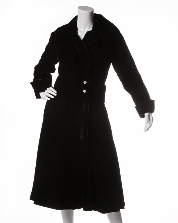Fabulous early 1970's silk velvet evening coat with rhinestone buttons. Accent cuffs, a generous lapel and black satin finishing. No makers label but there is a union tag which dates this coat to the early 70's.

Measurements:

Bust: 36