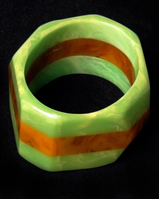 We LOVE this Bakelite statement bracelet. So unique! Oval shaped with exterior angle points make this one a conversation starter. Fused marbled melon and cantaloupe colors. Very reminiscent of Dombek Bakelite which is known for color blocking and