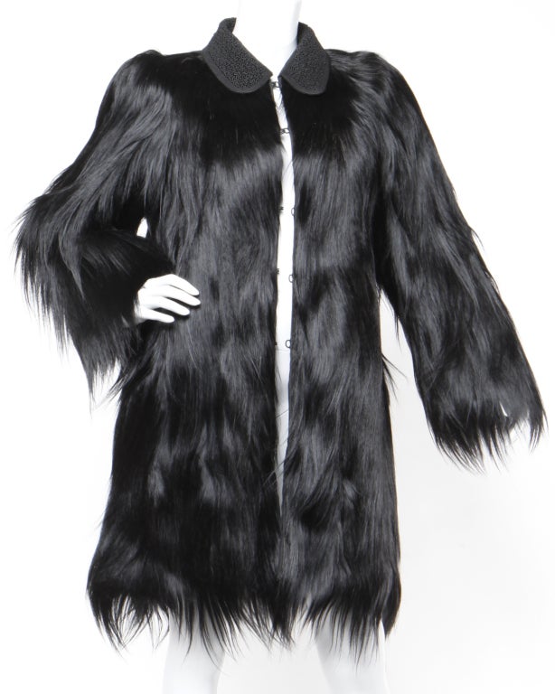 Jet black glossy monkey fur coat in pristine condition! Long, shiny Gold Coast monkey fur is plush and thick with no dryness to the pelts. The coat is knee length with a fabric Peter Pan collar and front hook closure. No fading to the dark black