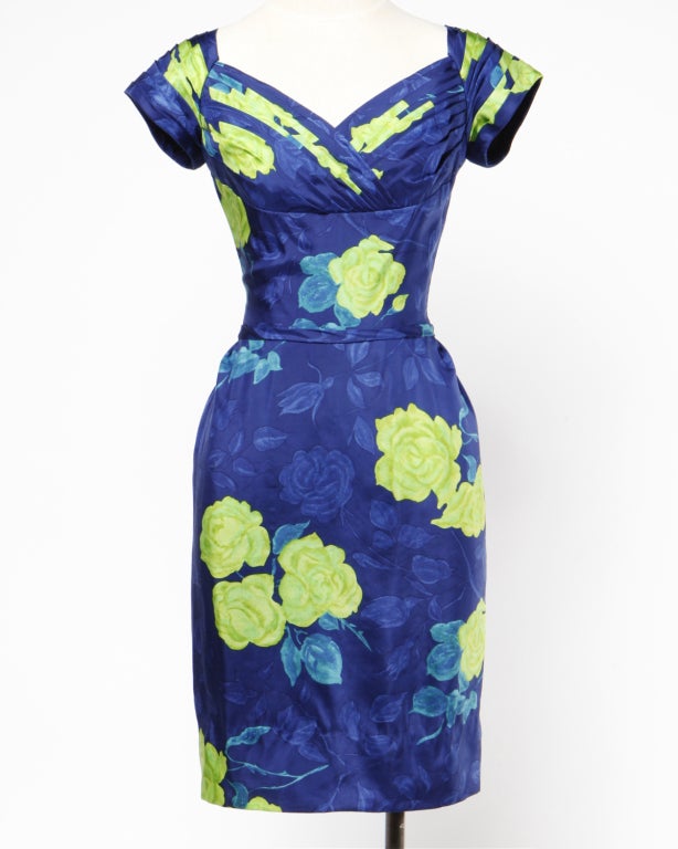 Creamy floral 100% silk wiggle dress from the 1950's- early 60's by upscale designer Philip Hulitar. Deep saturated tones of ocean blues with chartreuse roses. Pleated shelf bust and vintage hourglass silhouette. Tiny silk bow detail in the back of