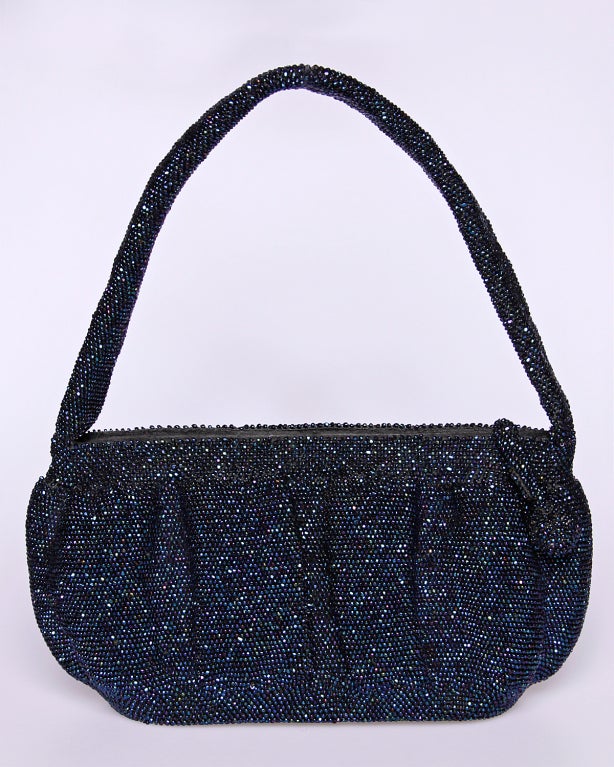 Gorgeous iridescent blue steel cut glass beaded bag done completely by hand! Encrusted in thousands of tiny sparkling metallic glass beads throughout, including the bottom and handle. Brown satin interior is clean and features and inside pocket for
