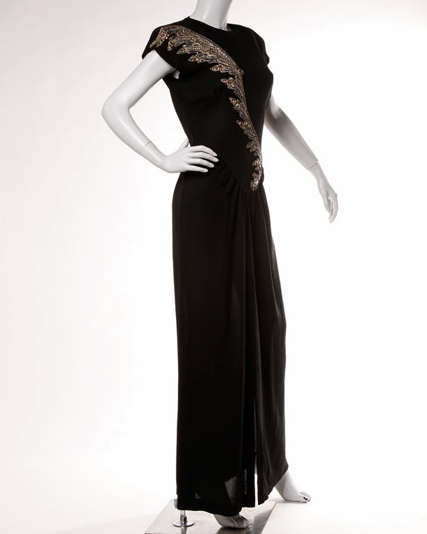 Gorgeous 1940's black crepe dress with metallic sequin and beadwork across the front which is all done by hand. Front slit and open cut out back. Built in 1940's shoulder pads for an early 20th century silhouette. Unlined. Side metal zip
