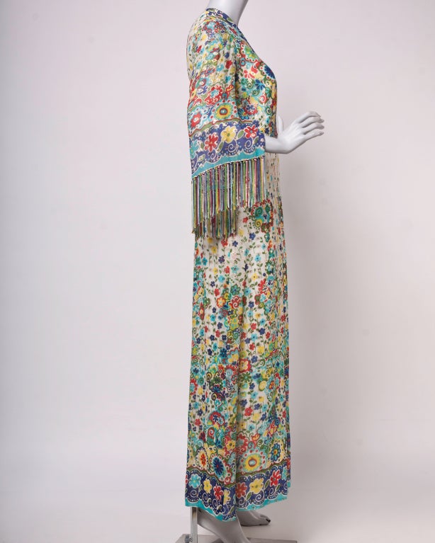 Beautiful, rare full-length silk dress by Nat Kaplan. Delicate floral print skirt, structured bodice with metallic details.  Sheer, fringed sleeves.
 
Fully lined. Back zip and hook closure.

DETAILS:

Circa: 1970s
Label: Nat Kaplan
Marked