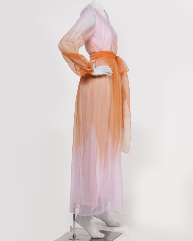 Vibrant orange and pink ombré maxi dress with sheer sleeves and matching waist sash. Gorgeous dip dye fabric. Fully lined. Back zip and hook closure. Waist sash included.

DETAILS:

Circa: 1970s
Label: Posh by Jay Anderson
Estimated Size: