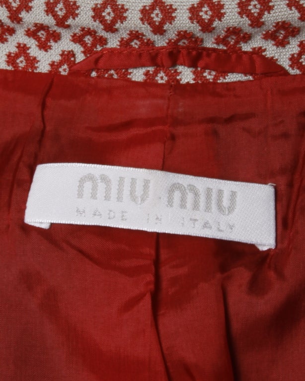 Purchased in Milan in 1996! Structured 90s Miu Miu jacket and skirt suit in an all over red diamond pattern. Buckle details at wrists on jacket and at back of skirt.

Jacket: Fully lined. Front button closure. Front pockets. Skirt: Fully lined.