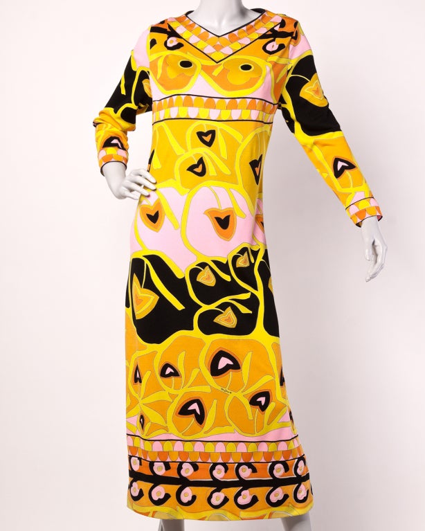 Colorful jersey knit maxi dress by highly collectible print designer Mr. Dino. Signed on the bottom front, this dress features long sleeves, a high side slit on one side, and rear zip closure. It is unlined.
