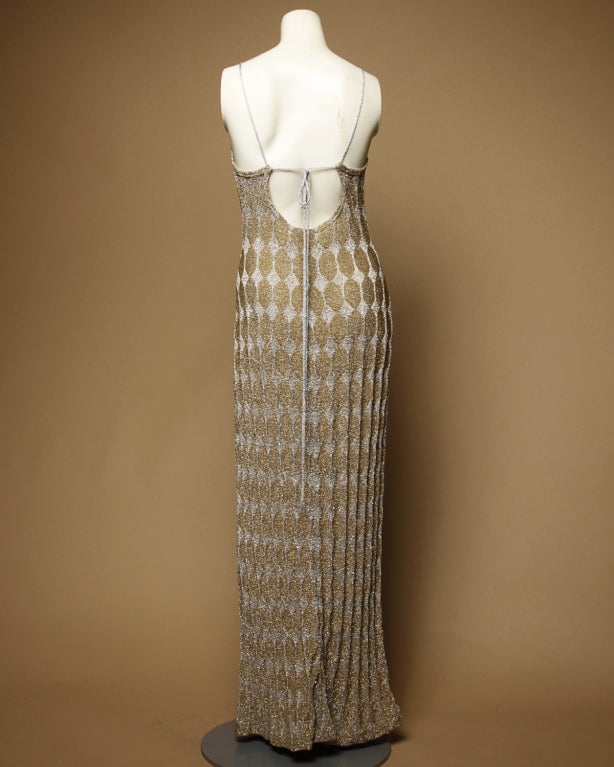 Stunning metallic silver and gold geometric knit maxi dress by Rudi Gernreich in collaboration with Harmon Knits. Sultry plunging back and unique tie closure. Unlined.

Marked Size: 8
Estimated Size: 4-6
Designer: Rudi Gernreich
Fabric: